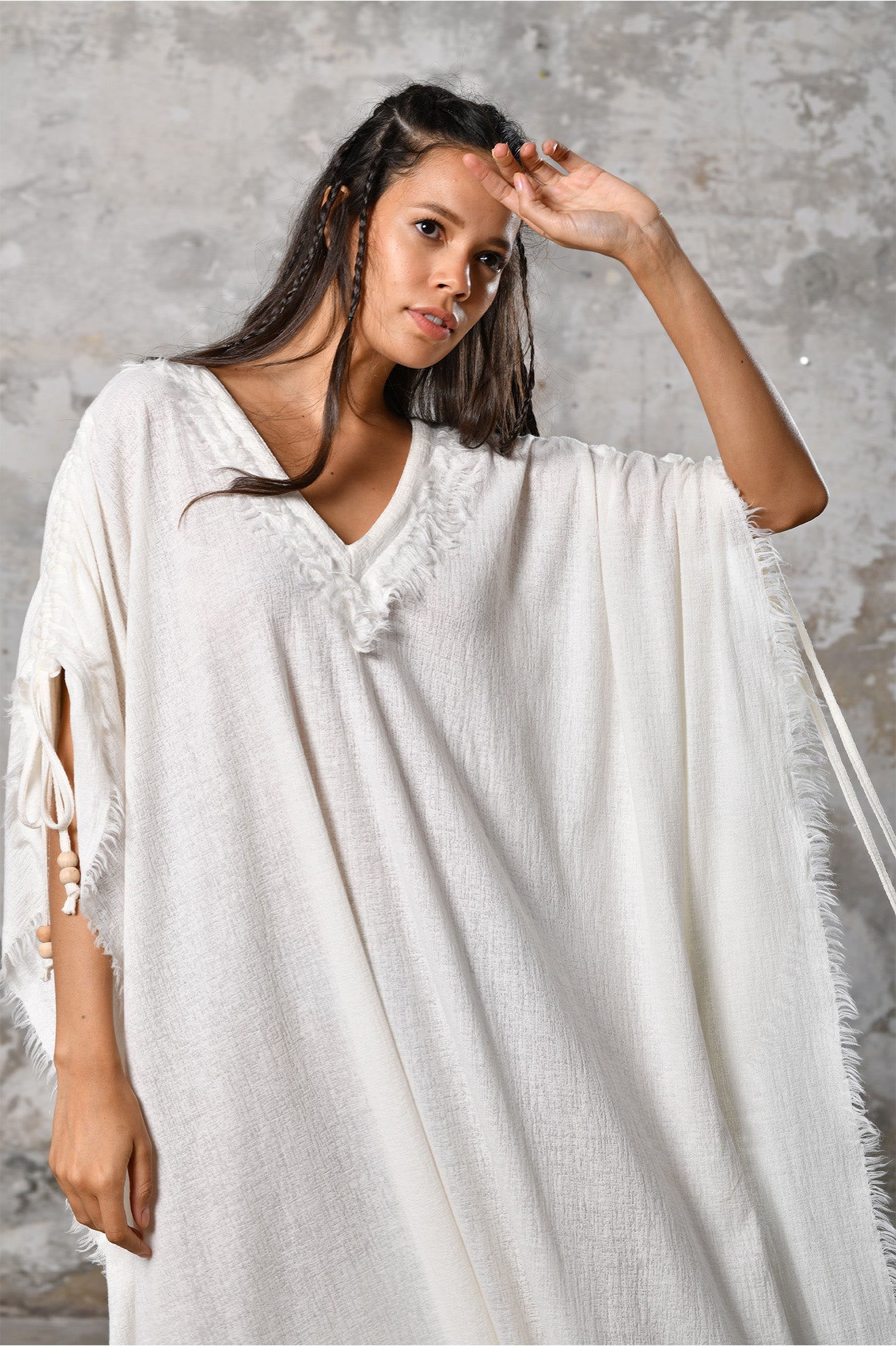 A versatile, White earthy goddess dress that embodies boho-chic style. Crafted from the softest cotton fabric, this garment offers both comfort and a fashion statement. The dress can be worn in two distinct styles, either as a kaftan or a sultry dress, with a simple change in the way you put it on. Its natural and ethereal design exudes a warm, comforting feeling against your skin, making it a must-have addition to your wardrobe for those seeking a harmonious blend of style and comfort.