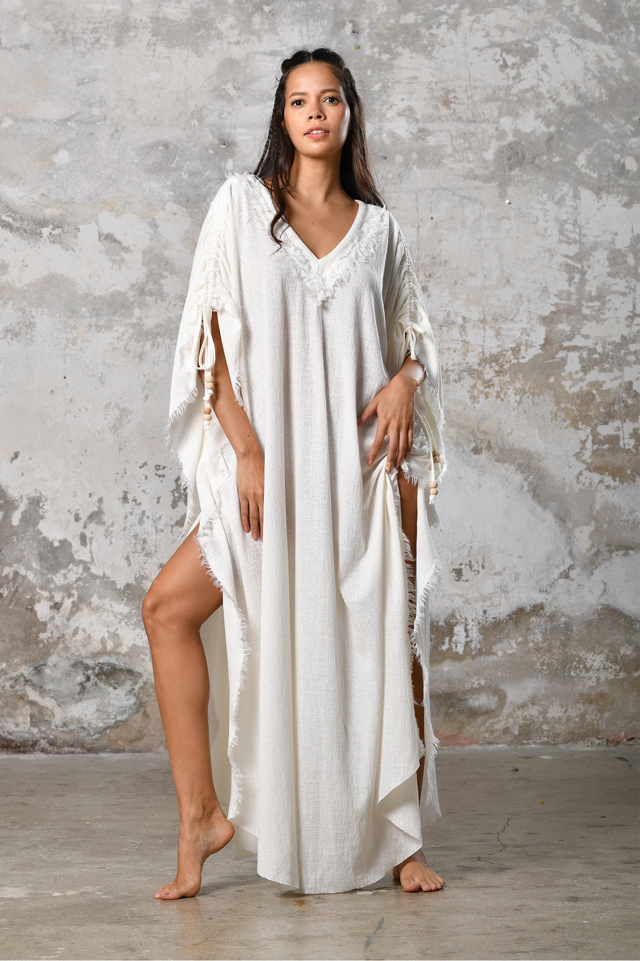 A versatile, White earthy goddess dress that embodies boho-chic style. Crafted from the softest cotton fabric, this garment offers both comfort and a fashion statement. The dress can be worn in two distinct styles, either as a kaftan or a sultry dress, with a simple change in the way you put it on. Its natural and ethereal design exudes a warm, comforting feeling against your skin, making it a must-have addition to your wardrobe for those seeking a harmonious blend of style and comfort.