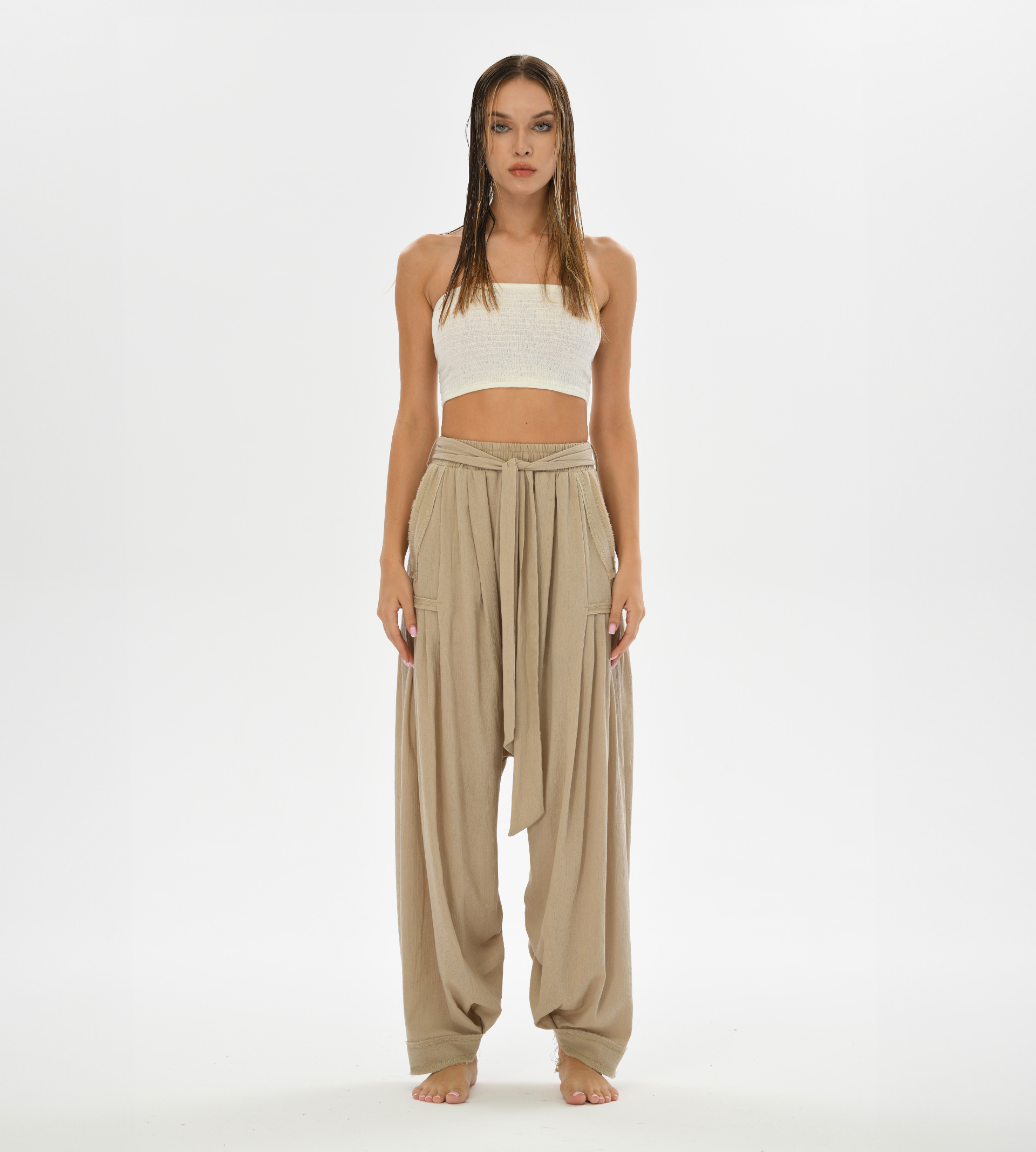 Women’s loose beige pants with a harem style cut, crafted from soft cotton for casual boho chic looks or yoga sessions.